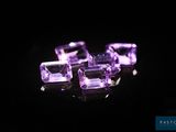 trois améthystes violettes posées sur une surface noire