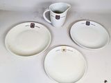 trois assiettes blanches et un pichet sont posés sur une table
