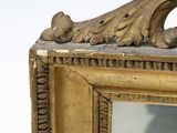 a mirror with a gold frame and a bird on it