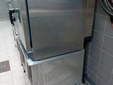 stainless steel refrigerator in a commercial kitchen with a red fire hydrant in the corner