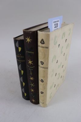 trois livres posés l'un à côté de l'autre sur une table