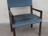 a blue chair that is sitting in front of a white wall