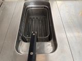 a deep fryer in the middle of a stainless steel sink