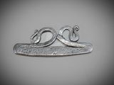 un gros plan d'un objet métallique sur lequel figure un serpent