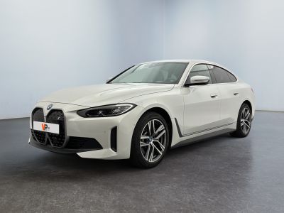 a white bmw car is parked in a large room