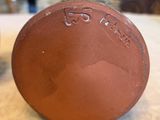 a close up of a brown vase on a table