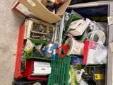 une valise remplie d'objets posée par terre