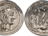 a silver coin with an image of a woman and an owl on it