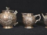 three pieces of silverware on a black surface with a black background