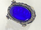 an image of a blue glass ring sitting on top of a white surface