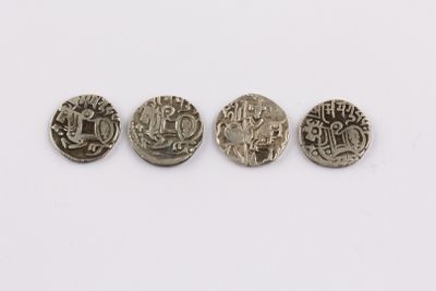 three silver coins with different designs on them on a white surface