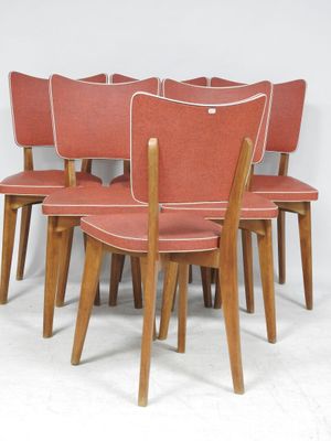 six chaises alignées sur une surface blanche