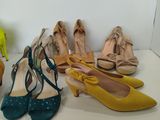 several pairs of women ' s shoes are lined up on a shelf