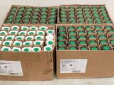 boxes of green and white cupcakes sitting on top of a counter