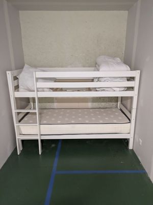 a bunk bed in a small room with a green floor