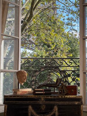 a trunk sitting in front of a window with a statue on it