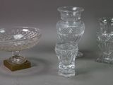 three glass vases and a bowl are sitting on a table