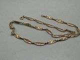 a close up of a gold chain on a white surface