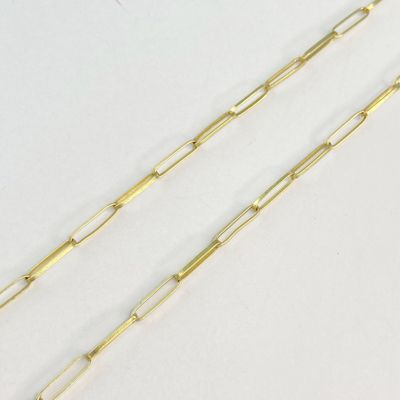 une paire de trombones plaqués or sur une surface blanche