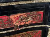 a black and red chest of drawers with gold trimmings