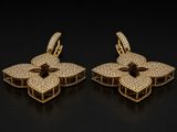 a pair of gold earrings with diamonds on a black background