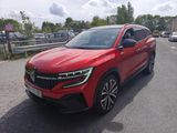 une voiture rouge garée sur le bord de la route