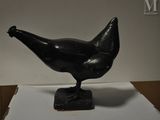 une statue représentant un oiseau noir perché sur une boîte blanche