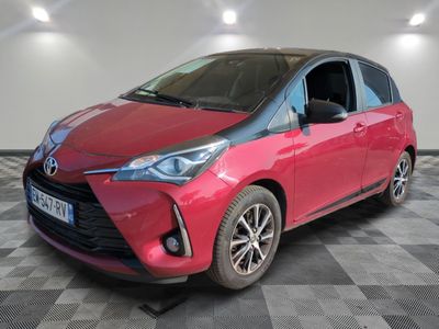 une Toyota Yaris rouge garée sur un sol à damier