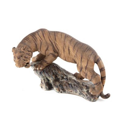 figurine représentant un tigre posé sur une souche d'arbre, sur fond blanc
