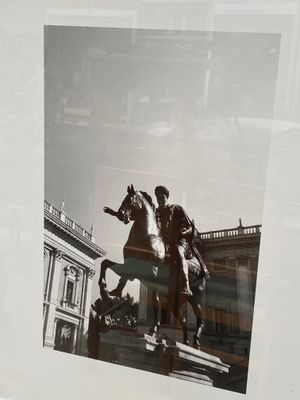 une photo en noir et blanc d'un homme à cheval devant un bâtiment