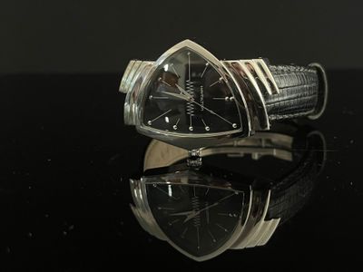 an image of a black and silver watch on a black surface