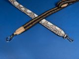 two snakeskin strap with a metal hook on a blue background
