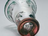 a glass bottle with a red cap on a white surface