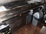 an image of a commercial kitchen with a grill and trash cans