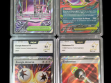 four different pokemon cards in plastic cases on a black background