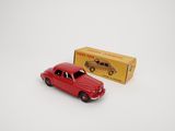 une image représentant une petite voiture rouge à côté d'une boîte jaune
