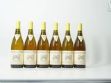 plusieurs bouteilles de vin sont alignées sur une étagère