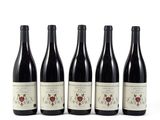 quatre bouteilles de vin rouge sont alignées sur une surface blanche