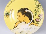 a yellow plate with a picture of a woman and a bird on it