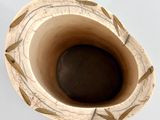 a close up of a vase on a white surface