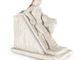 statue représentant une femme assise sur un bloc de pierre, avec un oiseau perché sur son bras
