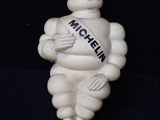 une figurine représentant un homme tenant une écharpe à la main