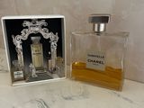 a bottle of perfume sitting on a counter next to a mirror