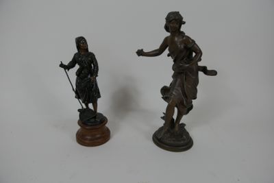 deux statues en bronze représentant une femme et un homme, posées sur un socle