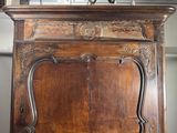 a wooden armoire with a clock on top of it