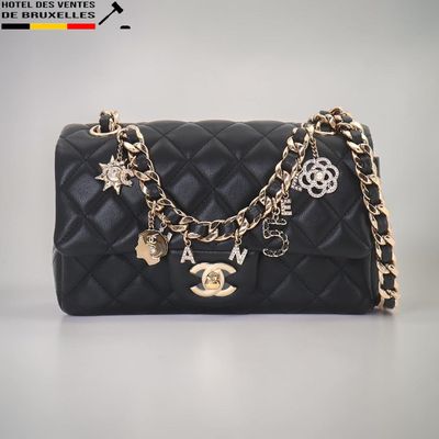 Sac à main Chanel en cuir matelassé noir, avec chaîne dorée et breloques