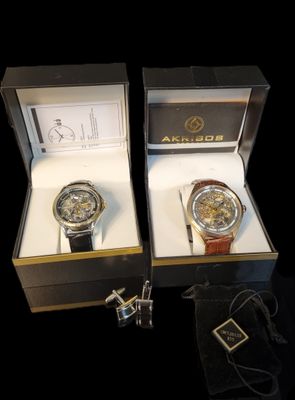 pair of watches in a box on a black background