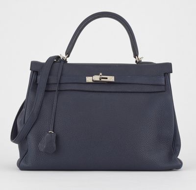 un sac à main en cuir bleu muni d'un fermoir métallique sur la poignée