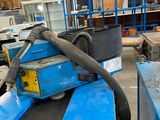 a blue machine that is sitting in a warehouse