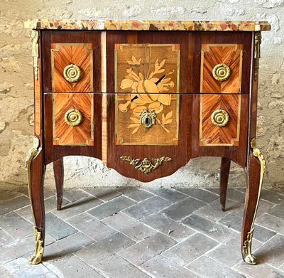 a small chest of drawers with a clock on top of it